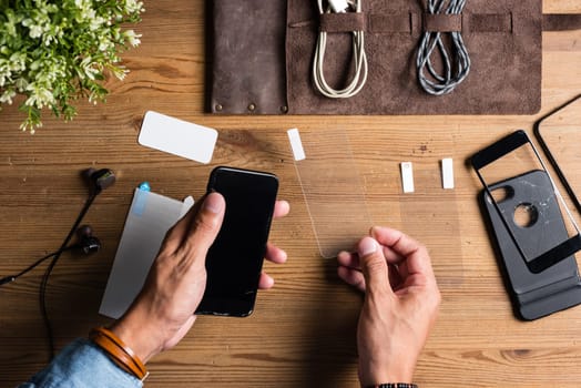 The man replacing the broken tempered glass screen protector for smartphone.