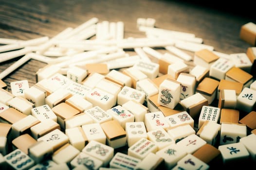 Many old mahjong tiles on wooden table. Mahjong is the ancient asian board game.