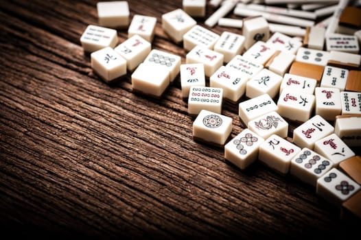 Many old mahjong tiles on wooden table. Mahjong is the ancient asian board game.