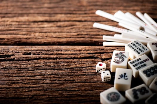 Many old mahjong tiles on wooden table. Mahjong is the ancient asian board game.