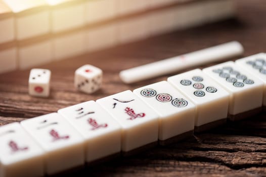 Playing Mahjong on wooden table. Mahjong is the ancient asian board game.