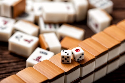 Playing Mahjong on wooden table. Mahjong is the ancient asian board game.