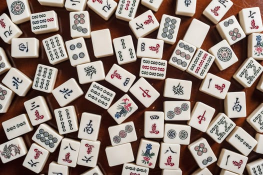 Many old mahjong tiles on wooden table. Mahjong is the ancient asian board game.