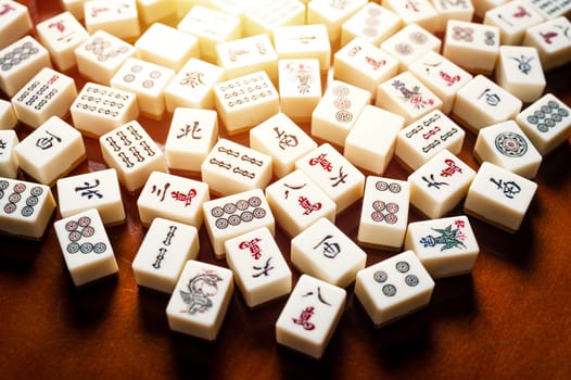 Many old mahjong tiles on wooden table. Mahjong is the ancient asian board game.