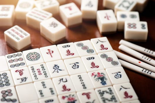 Many old mahjong tiles on wooden table. Mahjong is the ancient asian board game.