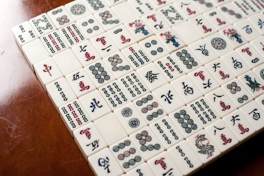 Many old mahjong tiles on wooden table. Mahjong is the ancient asian board game.