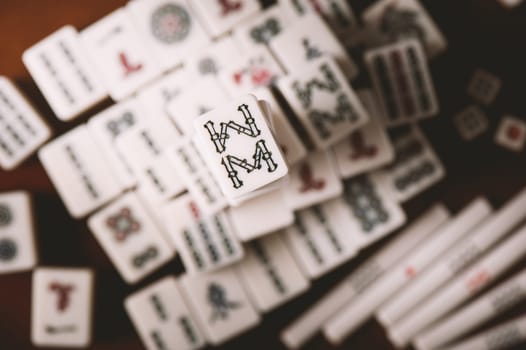 Many old mahjong tiles on wooden table. Mahjong is the ancient asian board game.