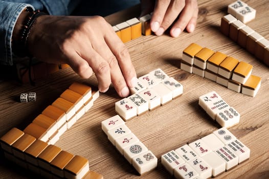 Playing Mahjong on wooden table. Mahjong is the ancient asian board game.