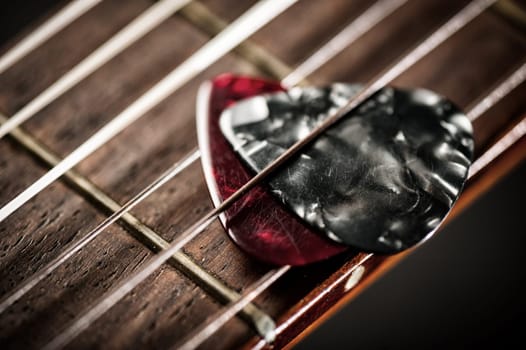 Closeup guitar pick on an old classical guitar. A guitar pick is a plectrum used for guitars.