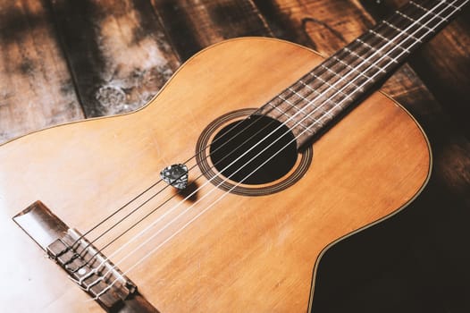 Closeup guitar pick on an old classical guitar. A guitar pick is a plectrum used for guitars.