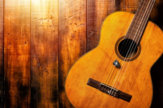 classical guitar with guitar pick on wooden background