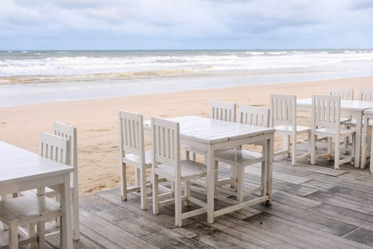 Empty white wooden dinning table at the beach.