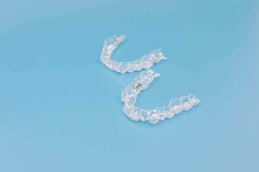 Night mouth guard. Transparent dental aligners for maxillary and mandibular teeth on blue background, Space For Text. Braces, Alignment of teeth. Orthodontic dentistry. Dental care. Horizontal