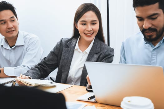 Multiracial analyst team use BI dashboard data to analyze financial report on meeting table. Group of diverse business people utilize data analysis by FIntech for success business marketing. Concord