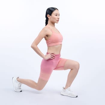 Young attractive asian woman in sportswear stretching before fitness exercise routine. Healthy body care workout with athletic woman warming up on studio shot isolated background. Vigorous