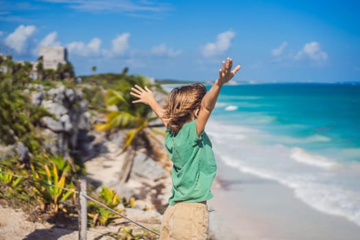 Boy tourist enjoying the view Pre-Columbian Mayan walled city of Tulum, Quintana Roo, Mexico, North America, Tulum, Mexico. El Castillo - castle the Mayan city of Tulum main temple.