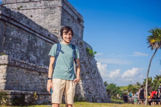 Male tourist enjoying the view Pre-Columbian Mayan walled city of Tulum, Quintana Roo, Mexico, North America, Tulum, Mexico. El Castillo - castle the Mayan city of Tulum main temple.