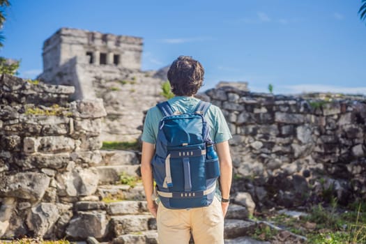 Male tourist enjoying the view Pre-Columbian Mayan walled city of Tulum, Quintana Roo, Mexico, North America, Tulum, Mexico. El Castillo - castle the Mayan city of Tulum main temple.