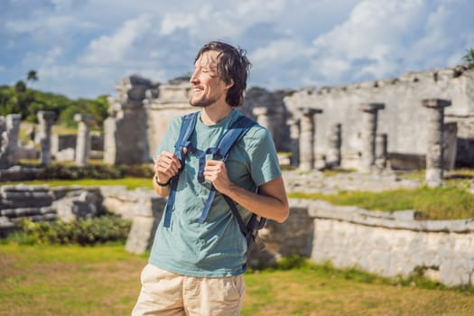 Male tourist enjoying the view Pre-Columbian Mayan walled city of Tulum, Quintana Roo, Mexico, North America, Tulum, Mexico. El Castillo - castle the Mayan city of Tulum main temple.