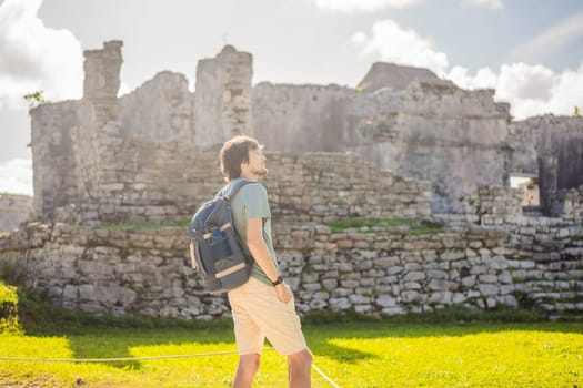 Male tourist enjoying the view Pre-Columbian Mayan walled city of Tulum, Quintana Roo, Mexico, North America, Tulum, Mexico. El Castillo - castle the Mayan city of Tulum main temple.