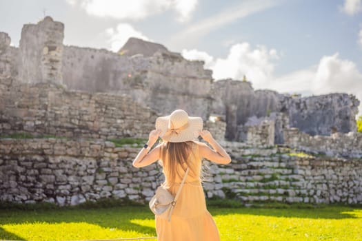 Woman tourist enjoying the view Pre-Columbian Mayan walled city of Tulum, Quintana Roo, Mexico, North America, Tulum, Mexico. El Castillo - castle the Mayan city of Tulum main temple.