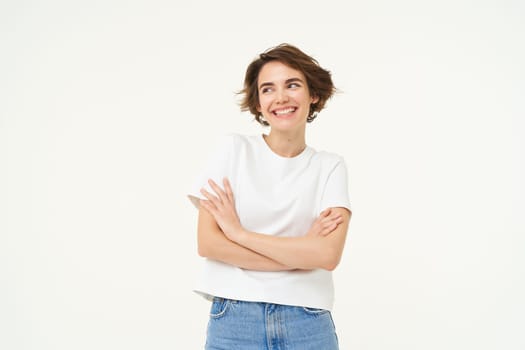 Portrait of cute brunette woman with confident smile, cross arms on chest, being self-assured, standing isolated over white background.