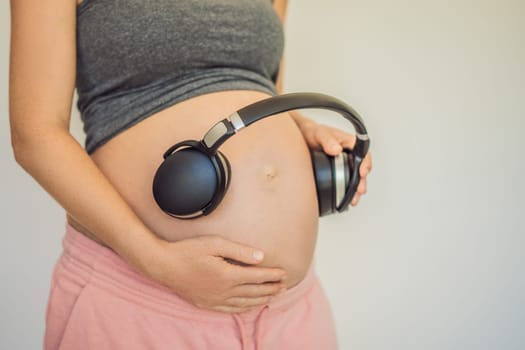 Melodies in the womb: Headphones placed on a pregnant belly, bonding through music, a heartwarming connection between mother and baby.