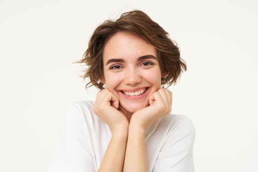 Close up of excited young brunette woman, looking with anticipation at camera, dreaming, wishing for something, isolated over white background.