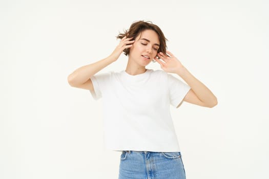 Portrait of carefree girl, gentle and feminine woman with short hair, laughing, posing over white studio background. Copy space