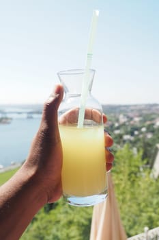 holding a glass of orange juice close up ,