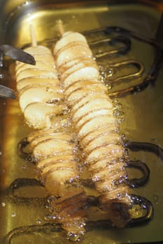 fried chips potatoes frying in boiling hot oil in a deep fryer