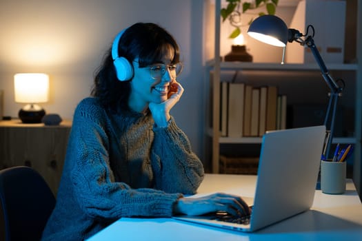 Caucasian woman working late at night with computer at home. Technology and lifestyle concept.