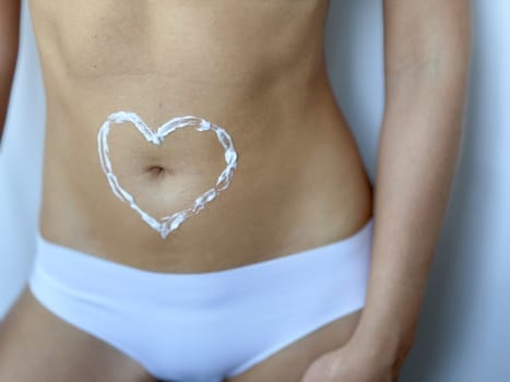 Hydrating skincare. Heart on female abdomen promoting wellness and self care.