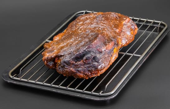 A beautifully smoked brisket rests on a cooling rack, showcasing its rich colors and savory texture, inviting all