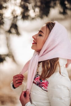 Beautiful Russian woman in a headscarf, portrait. A lovely woman smiles and looks at the camera in winter