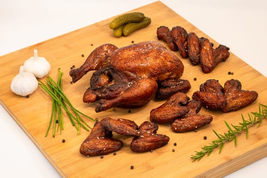 Enjoy grilled chicken and crispy wings with fresh herbs, garlic, and tangy pickles on a rustic wooden board