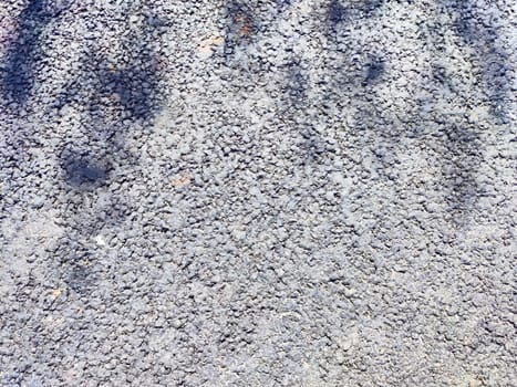 The surface displays a rough, gray texture with faint shadows cast overhead.