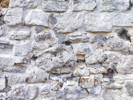 Close-up of a rough stone wall exhibiting unique textures and colors, showcasing the beauty of natural aging and erosion.