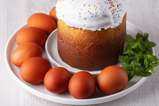 Delicious Easter cake and eggs on light background.