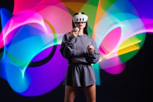 VR, AR, MR, XR Future technologies. Neon. Young girl in VR glasses in neon doing sports and playing a game. Concept of modern gadgets and technologies
