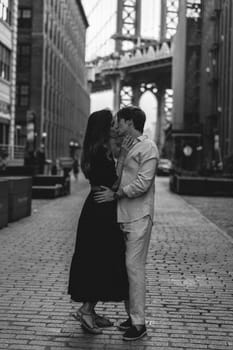A beautiful romantic moment has been perfectly captured between a loving couple amidst an urban setting backdrop. Dumbo in Brooklyn, New York.