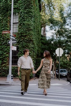 A romantic couple walks hand in hand, savoring the beautiful moments they share in a lush, ivycovered street