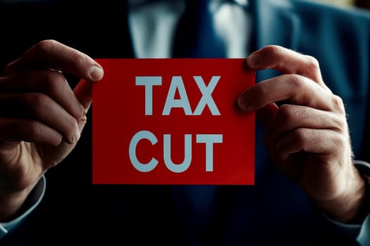 close up a businessman holding text display TAX CUT..