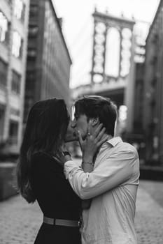 A beautiful romantic moment has been perfectly captured between a loving couple amidst an urban setting backdrop. Dumbo in Brooklyn, New York.