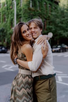 A romantic moment is captured between a couple in a vibrant urban setting filled with lush greenery