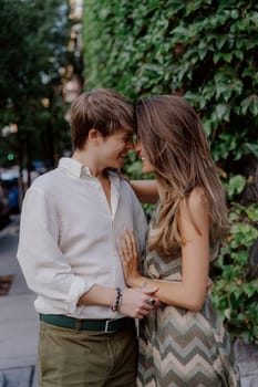 A couple lovingly shares a tender embrace in front of lush vibrant greenery, capturing intimate moments of deep love