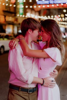 Beneath vibrant city lights, a loving couple shares an intimate moment, capturing their deep connection and affection