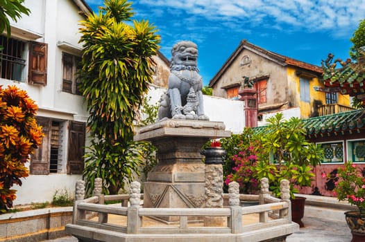 Lion animal statue on Asian Buddhist pagoda in summer garden in Asia
