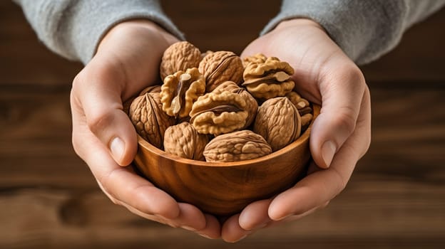 A person is carefully holding a beautifully crafted bowl filled with nutritious walnuts in their hands, emphasizing their natural goodness