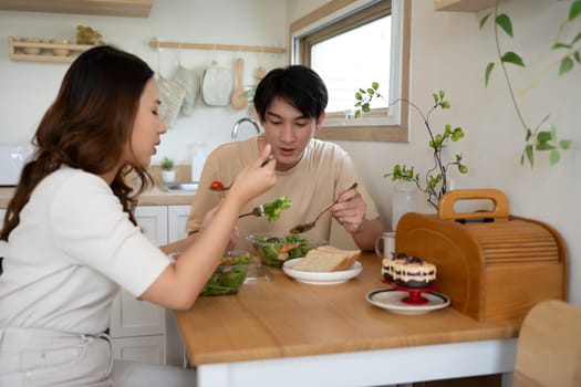 Happy millennial having nutritious meal in a cozy kitchen.